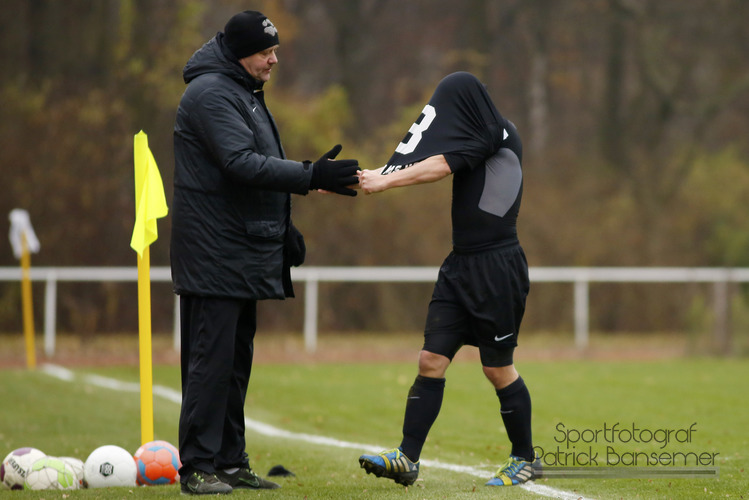 Berlin,  Deutschland 30. November 2014:
Bezirksliga - 14/15 - DJK Schwarz-Weiss NeukÃ¶lln vs. SG Stern Kaulsdorf

v.li. Trainer Heiko Lambert (DJK) klatscht bei der Auswechslung mit dem enttaueschten Robert Hilprecht (DJK) ab.